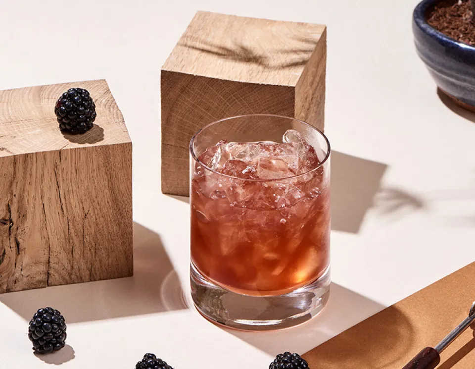 The Cointreau Bramble Cocktail surrounded by blackberries