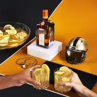 Two hands holding two glasses of Whiskey Punch in short glasses with lemon slices